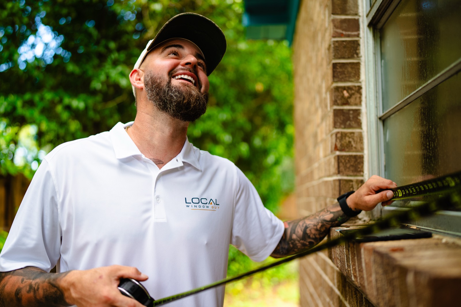 Local Window Guy owner measuring a window opening on a Pensacola brick home